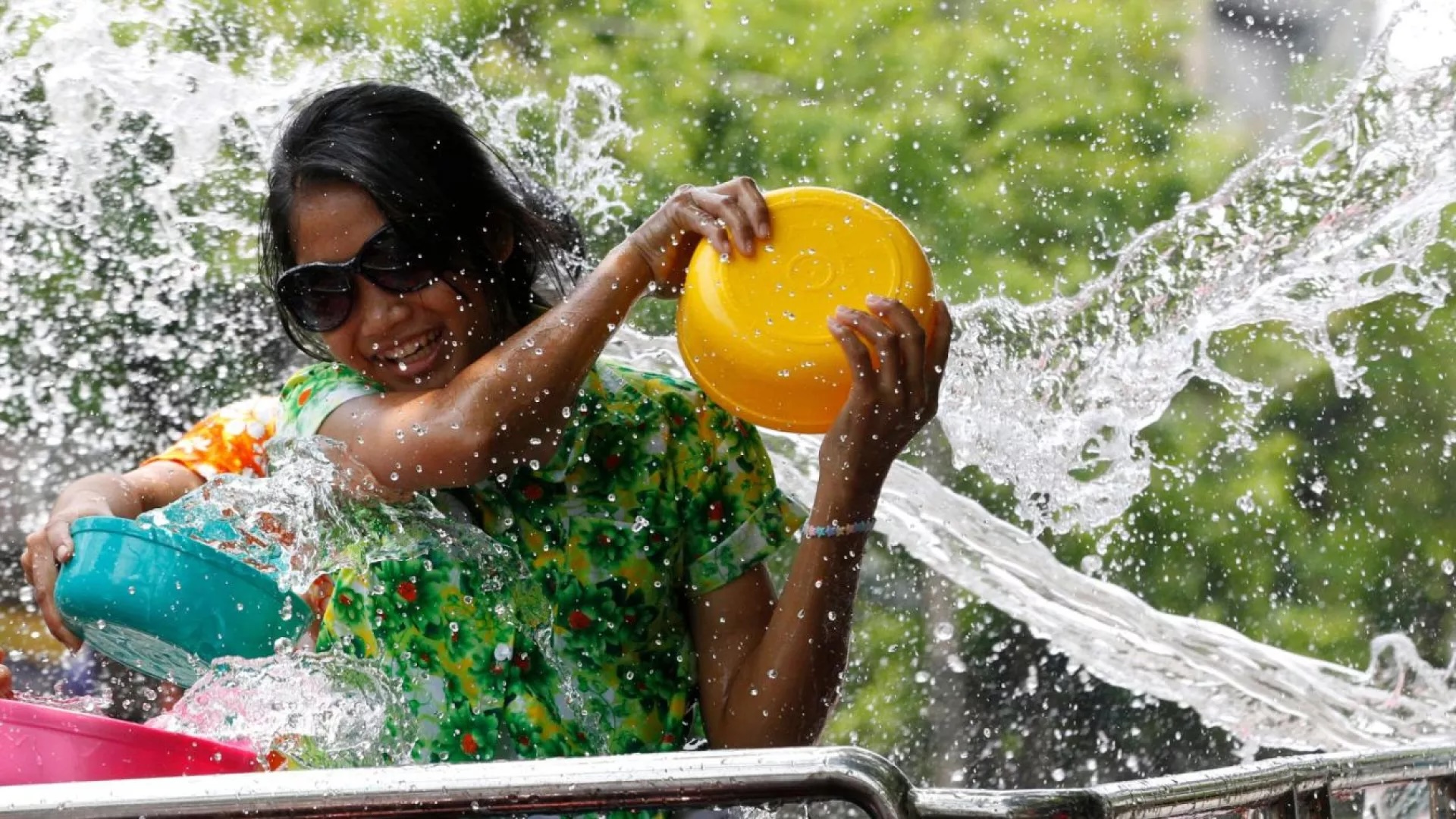 Lady getting soaked at the back of a truck in Songkran water festival