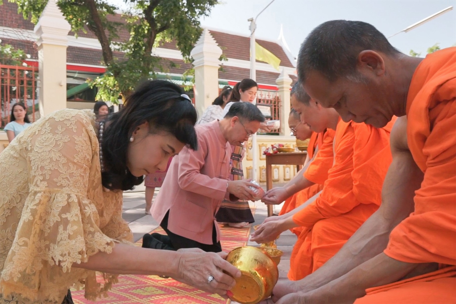Woman performing rod nam dam huua ceremony with monks