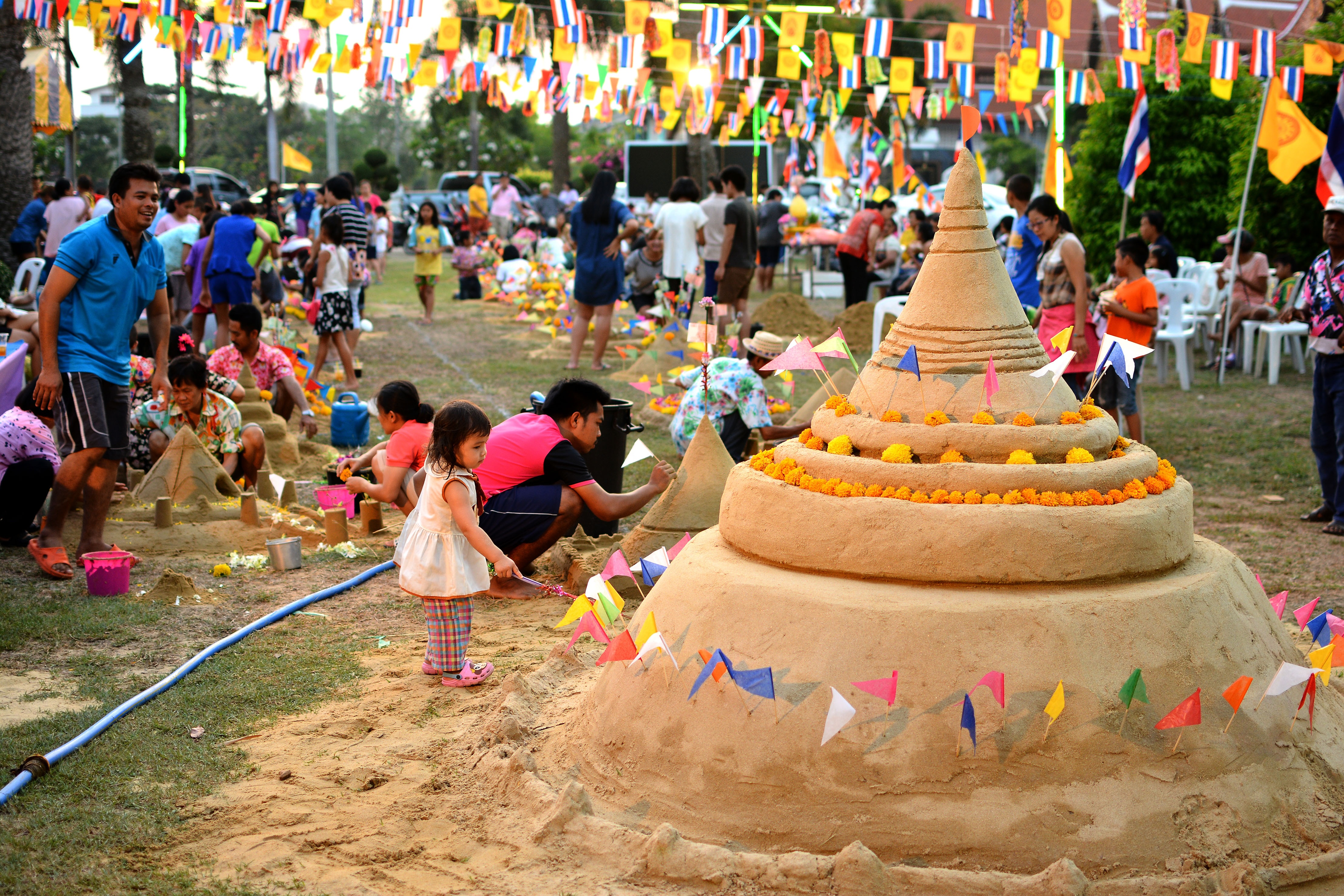 People building sand pagodas in a local temple